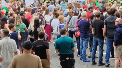 BBC Hundreds of protestors outside the FM's home