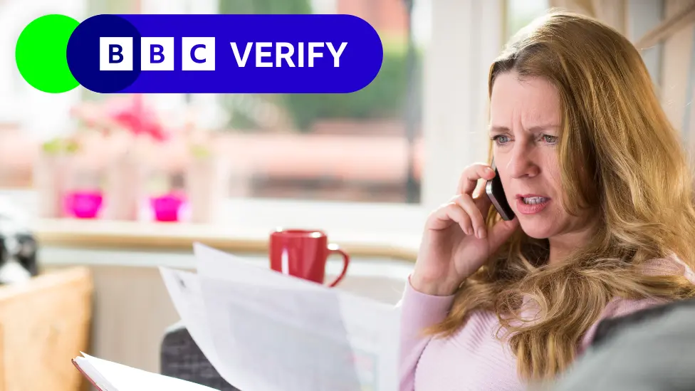 Getty Images Woman on phone looking at bills