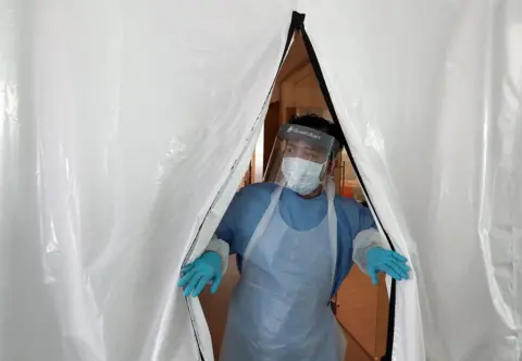 AFP Technician in PPE at entrance to new laboratory