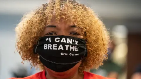 Getty Images Gwen Carr, the mother of Eric Garner, wearing a protective mask attends New York Governor Andrew Cuomo's daily media briefing at the Office of the Governor of the State of New York on 12 June 2020 in New York City
