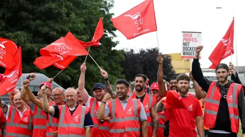 Reuters Workers protest outside of an entrance at the UK's biggest container port Felixstowe as they begin an 8-day strike,
