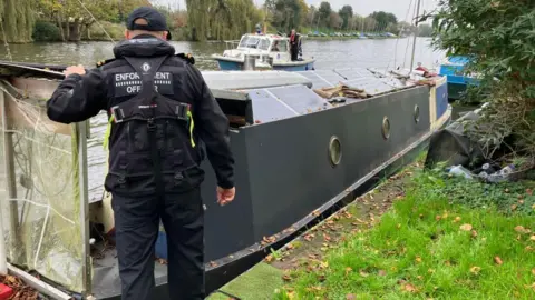 An Environment Agency officer inspects a boat.