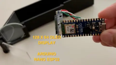 Milya Mohd Asyraf A small technical device which looks like a USB stick is held up to the camera 