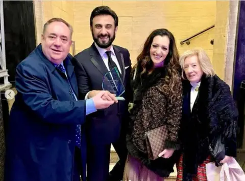 Zulfikar Sheikh/Instagram Alex Salmond, Zulfikar Sheikh, Tasmina Ahmed-Sheikh and Moira Salmond at an awards ceremony in London. Mr Sheikh and Mr Salmond hold the award as the group looks into the camera.