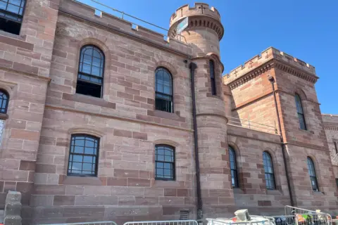 Exterior of Inverness Castle. The building is built of sandstone and there are several windows in the walls.