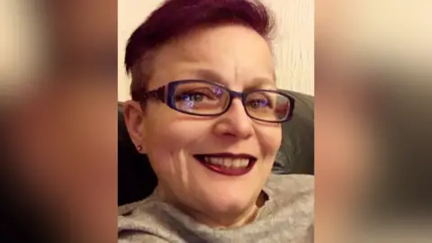 Other A headshot of Pam Dolan, who has short red hair and wears glasses