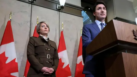 Getty Images Mélanie Joly, Menteri Luar Negeri Kanada, Kiri, dan Justin Trudeau, Perdana Menteri Kanada, selama konferensi pers di Ottawa, Ontario, Kanada, pada Selasa 4 Maret 2025.