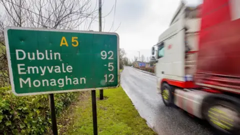 PA Media Lorry travelling past a green road sign on the A5