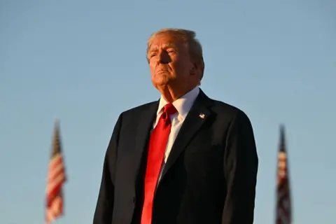 Getty Images Former US President and Republican presidential candidate Donald Trump looks on during a campaign rally at site of his first assassination attempt in Butler, Pennsylvania on October 5, 2024