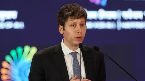 Sam Altman, wearing a dark suit and blue tie, gives a speech