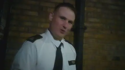 BBC A grab from footage of a man outside wearing a police uniform