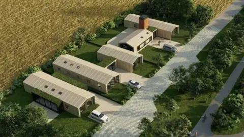 Four long, single-floor buildings with driveways and a small road running in front of them all. There is a field behind them. The view is from above.