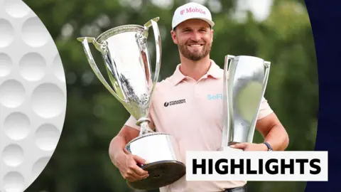 Wyndham Clark smiling and holding two trophies