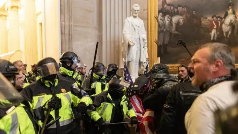 Getty Images Police face off against pro-Trump rioters beside Abraham Lincoln statue inside of the Capitol