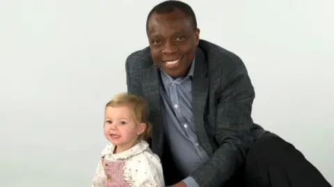 Fleur sitting with Ikenna Omeje in a studio shot