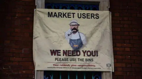 Getty Images A sign displayed at Smithfield Market urging people to use the rubbish bins. In a play of Lord Kitchener's war poster "Your Country Needs You" - a moustachioed man pointing at the viewer - the sign has a man wearing a butcher's outfit and the slogan says "We Need You, please use the bins"