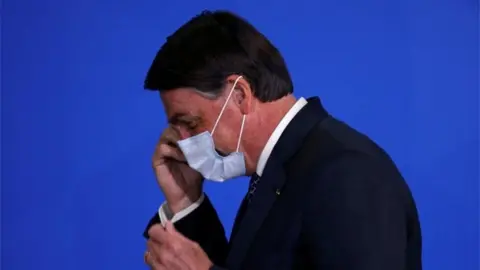 Reuters Side-view of President Bolsonaro wearing a mask