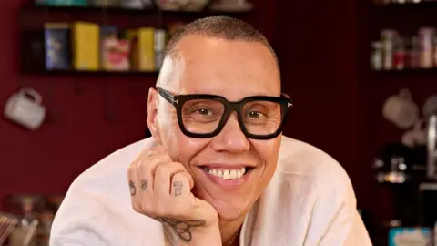 PA Media A close-up head and shoulders image of Gok Wan leaning forward and resting his chin on his hand. 