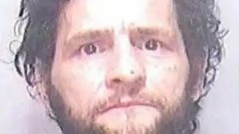 Man with curly dark hair and beard.