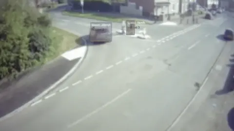 TfWM A vehicle is seen turning into the road with pedestrians standing safely in an area in the middle of the road.