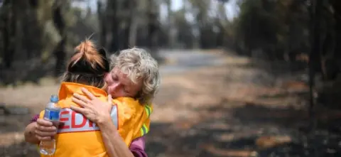 AFP A fruit farmer is comforted by a journalist in Batlow, New South Wales