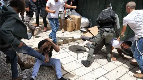 Getty Images Israeli police officer intervenes as Israelis beat two Palestinians (18/05/23)