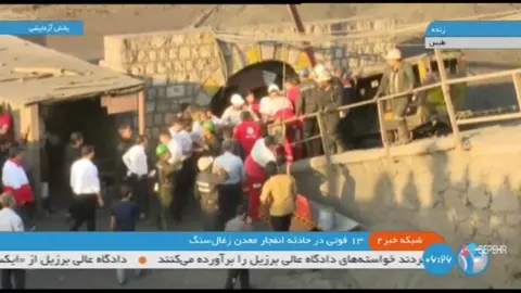 APTN A screengrab of Iranian state TV showng emergency personel and officials at the site of a coal mine explosion in Tabas