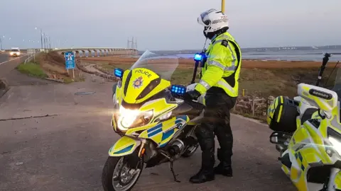 Gwent Police police officer next to motorbike