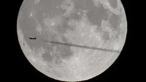 BBC Weather Watchers/Woody's Elf Spotted Norwegian Air Shuttle flight DY1811 transiting across the rising full moon.