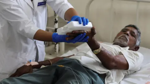 Reuters A nurse gives treatment to Dayabhai Parmar a 76-year-old patient of heat exhaustion inside a Heat Illness ward of a government hospital during a heatwave in Ahmedabad, India, May 25, 2024. REUTERS/Amit Dave