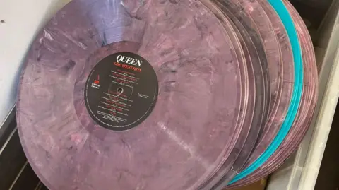 City of London Police A close up of a pink counterfeit vinyl from Queen. It is being stored in a clear box.