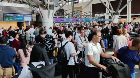Rajen Shah A landscape image of passengers queuing in an airport terminal