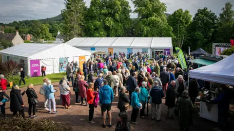 Borders Book Festival A large gathering of people visiting the Borders Book Festival with a two prominent white marquees and some smaller gazebos in the foregound