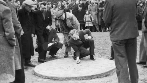 Getty Images A black and white image of Harry Langridge in action during traditional Good Friday World Marble Championships at Tinsley Green, Sussex, 23rd March 1951