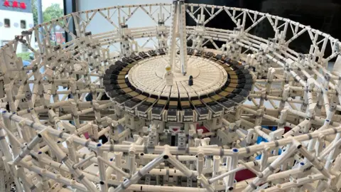 UOM A Lego reconstruction of the Lovell telescope at Jodrell Bank, with a small lego figure walking on the central dish.