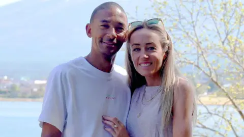 Michael Rimmer and Eilish McColgan smile while looking into the camera, shortly after getting engaged. The couple are standing in front of Mount Fiji.