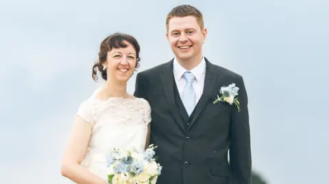 Contributed A brunette woman is wearing a wedding dress and carrying a bouquet. A sandy haired man is wearing a grey three-piece suit and pale blue tie with a flower in his lapel. Both are smiling.