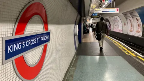 King's Cross platform shows passengers, Tube roundel
