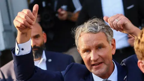 Bjorn Höcke (L), the leading candidate for the far-right Alternative for Germany (AfD) party, casts his ballot at a polling station in Bonhagen in the Thuringia state elections.