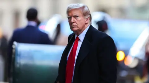 Getty Images Former US President Donald Trump arrives at 40 Wall Street after his court hearing to determine the date of his trial for allegedly covering up hush money payments linked to extramarital affairs in New York City on March 25, 2024