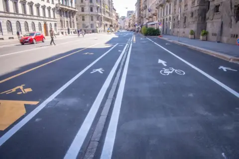 Getty Images A new scheme in Milan re-allocated car parking space for pedestrians and cyclists