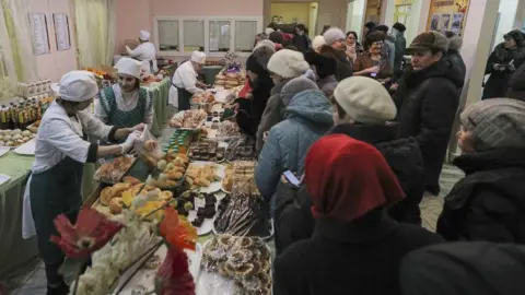 Reuters People queue for food at a polling station in Kazan, Russia, on 18 March 2018