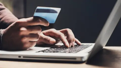 Getty Images Person using a credit card