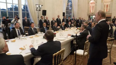 EPA Vladimir Putin (standing) at a meeting with Italian officials in Rome, 4 July