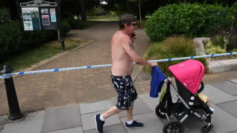 Getty Images Man walks past cordon in city