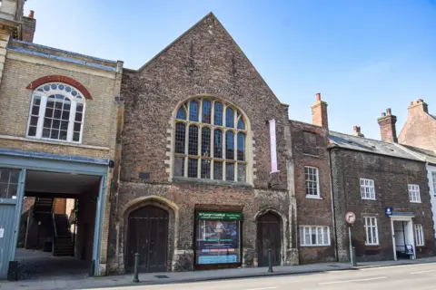 External view of The Guildhall in King's Lynn. 
The building is of brick, with a façade of chequered flushwork, with a 17th century porch.