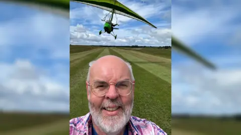 Colin MacKinnon Selfie of man underneath airplane