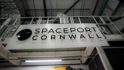 PA Media A black and white sign reading 'Spaceport Cornwall' on a building.