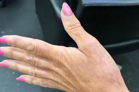 A hand with pink painted nails