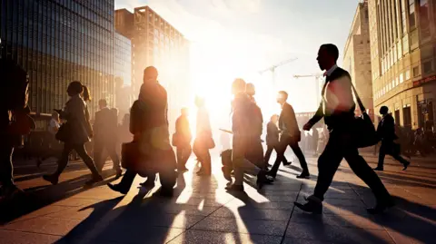 People walk to work as the sun rises on a city landscape